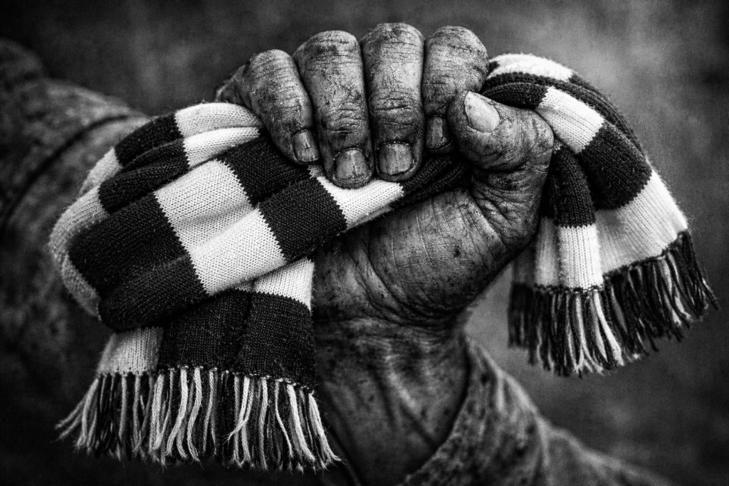 Mano trabajadora con bufanda de Unionistas, representando la humildad y el esfuerzo del equipo.
